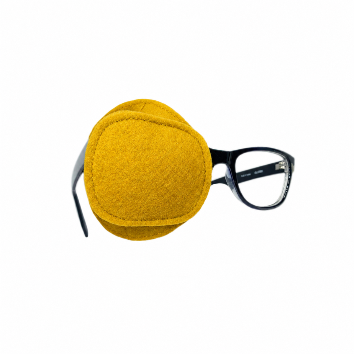 Mustard yellow wool felt eye patch with stitched center panel, shown on glasses